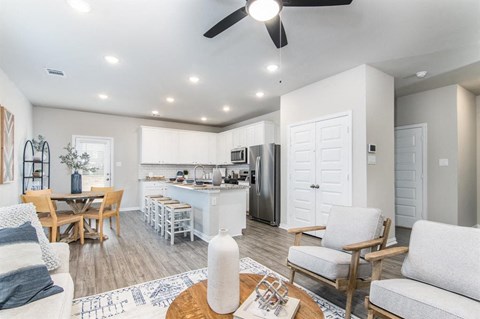 a living room and kitchen with a table and chairs